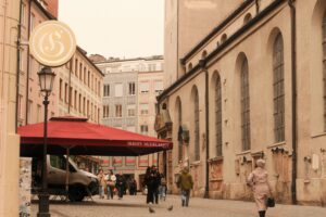 Charming Munich street view with historic architecture and outdoor cafe.